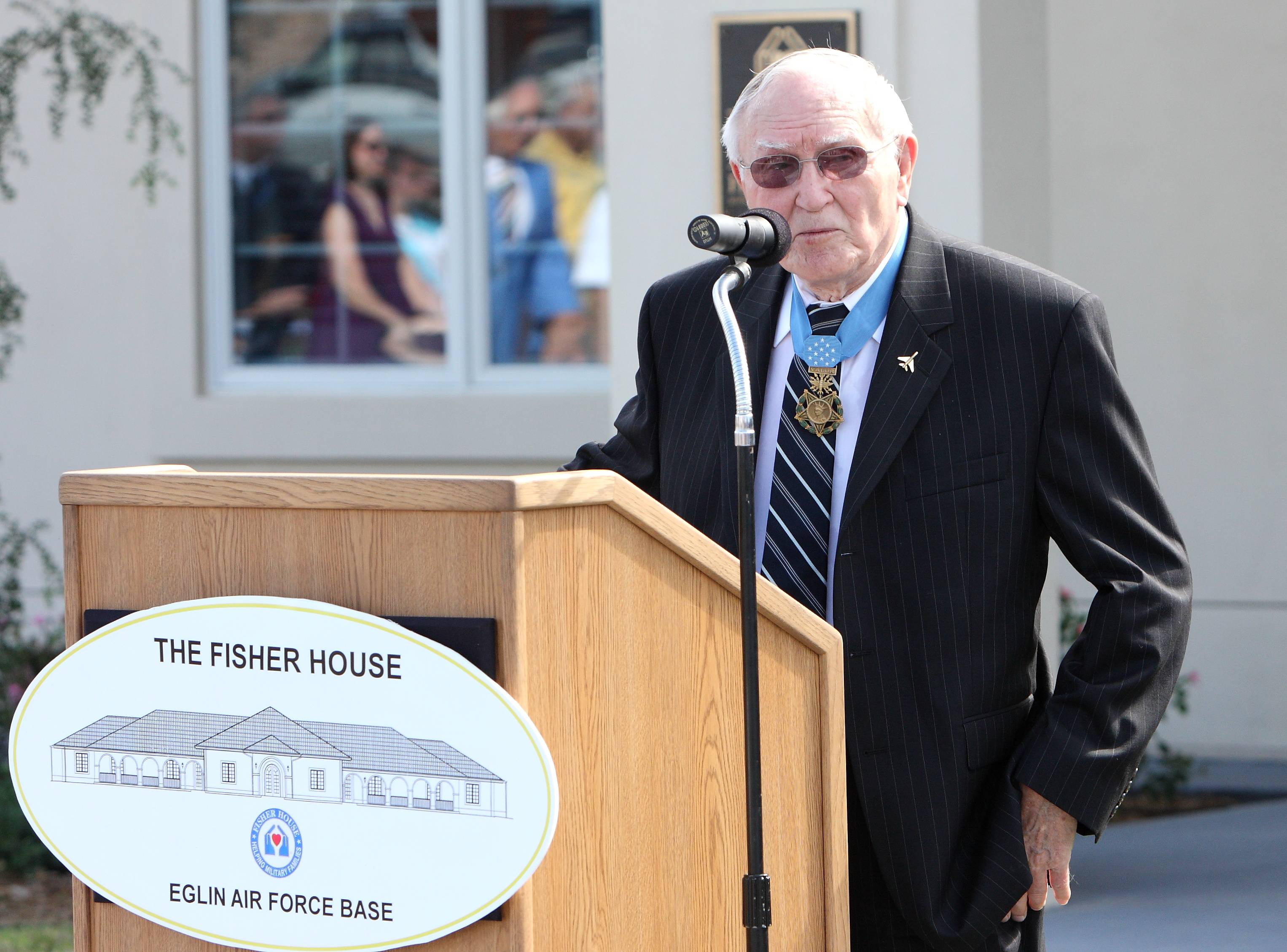 Col. Bud Day speaks at the podium during the 2010 dedication of the Fisher House of the Emerald Coast.