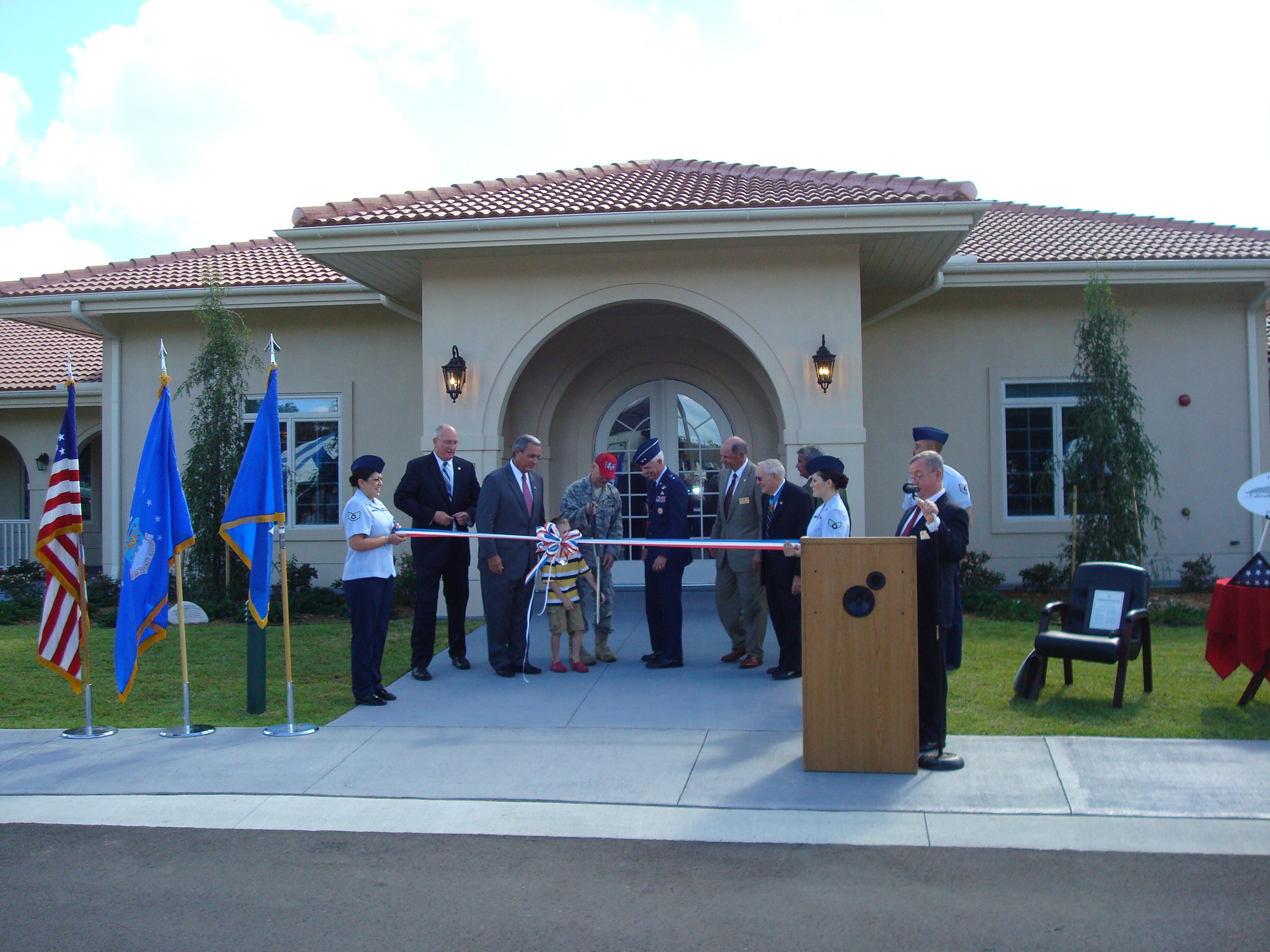 A military family cuts the ribbon at the 2010 opening of the Fisher House of the Emerald Coast.