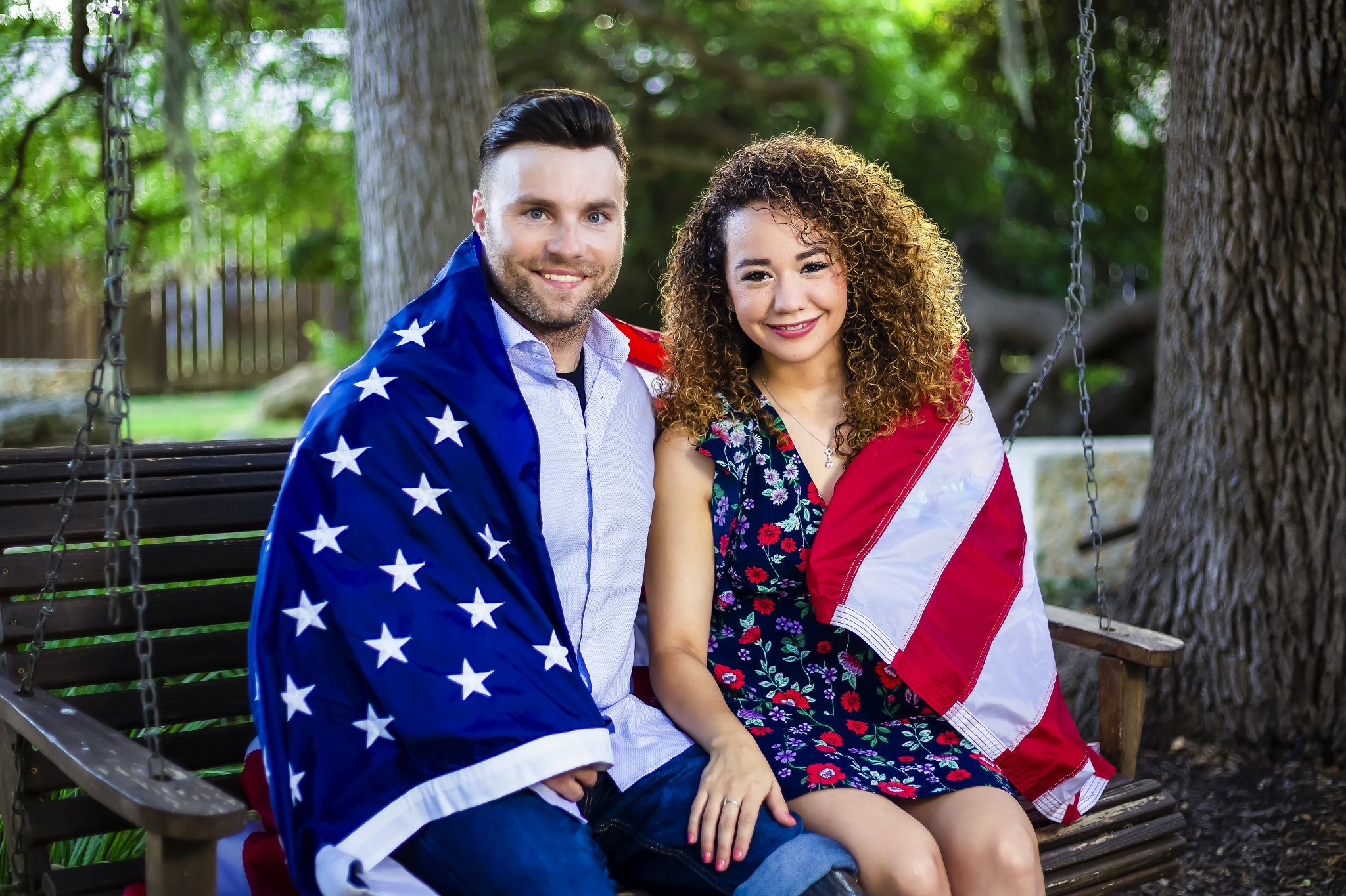 A military family holds an American flag together — the families Fisher House exists to serve.